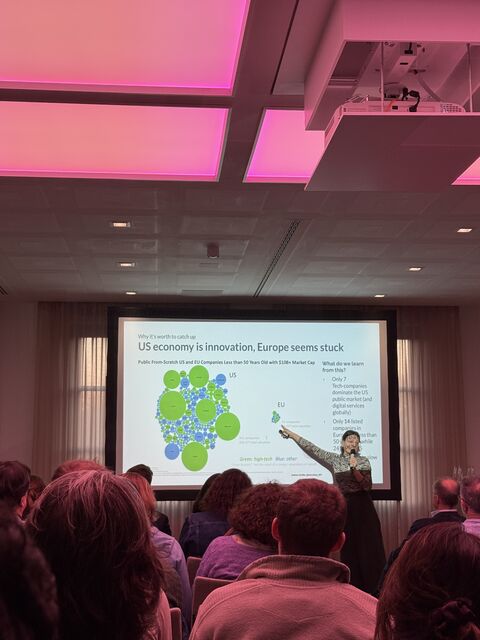 Speaker presenting US vs EU innovation slide with bubble chart